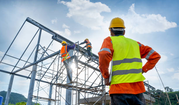 Construction site with workers wearing safety gear, highlighting the context of seasonal employment decisions.